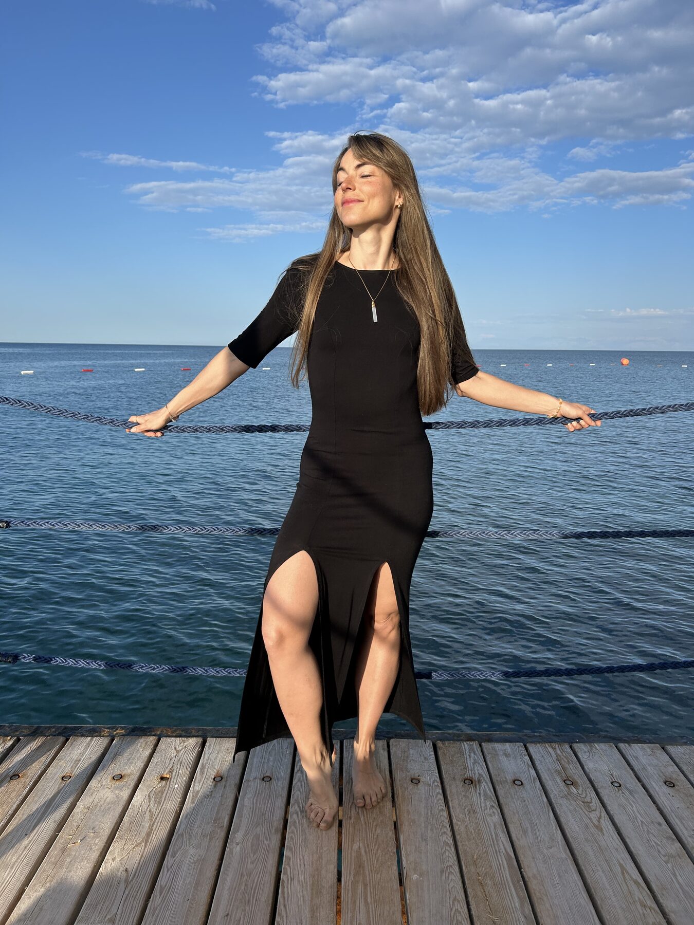 Coach at the sea, eyes closed, arms gently held wide